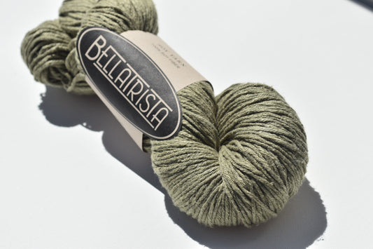 Skein of olive green Bellarista brand yarn on white background