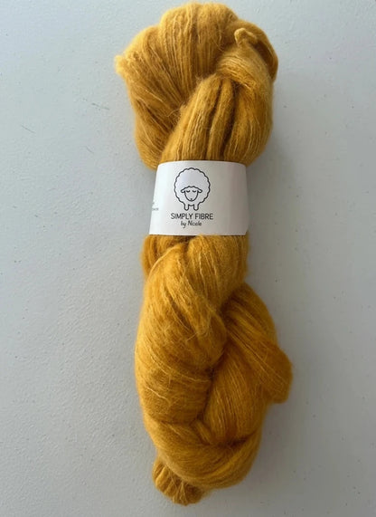 Mustard yellow yarn skein with a label on a white background
